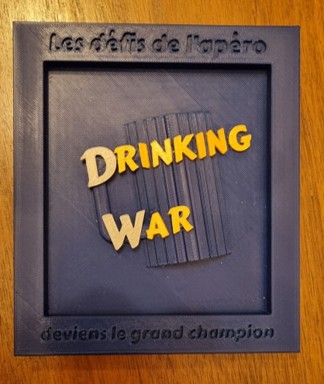 Détail du couvercle bleu avec écritures or et argent en relief "Drinking War" et "Les défis de l'apéro", réalisé en impression 3D.