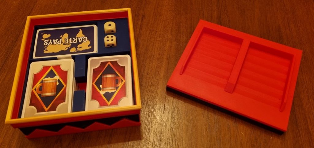 Couvercle rouge retourné servant de support de défausse pour deux piles de cartes du jeu Drinking War.