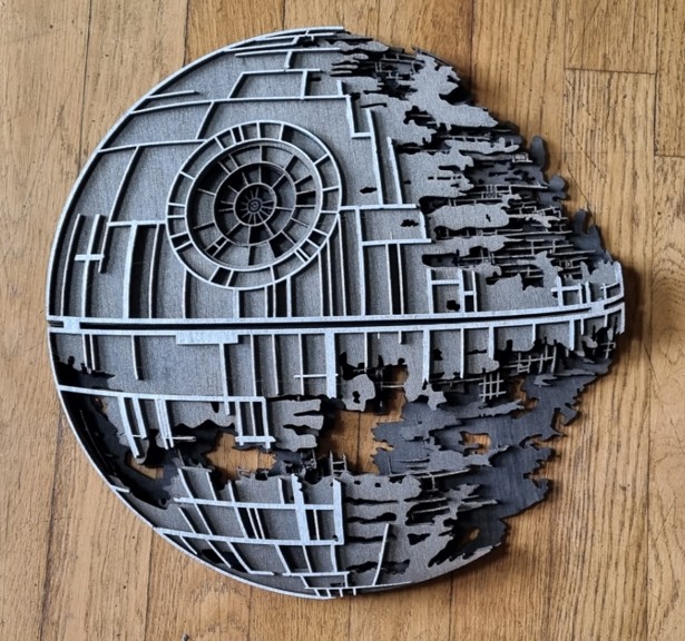 Maquette en relief de l'Étoile de la Mort de Star Wars réalisée en 5 couches de bois découpées au laser et peintes en dégradé.