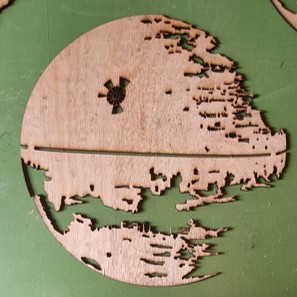 Deuxième épaisseur en bois brut découpée au laser avec les premières silhouettes de l'Étoile de la Mort.