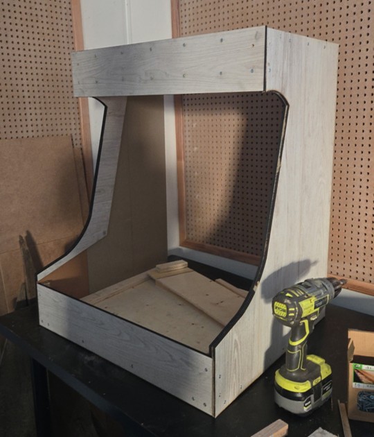 Structure en bois de la borne d'arcade bartop en cours d'assemblage avec visseuse